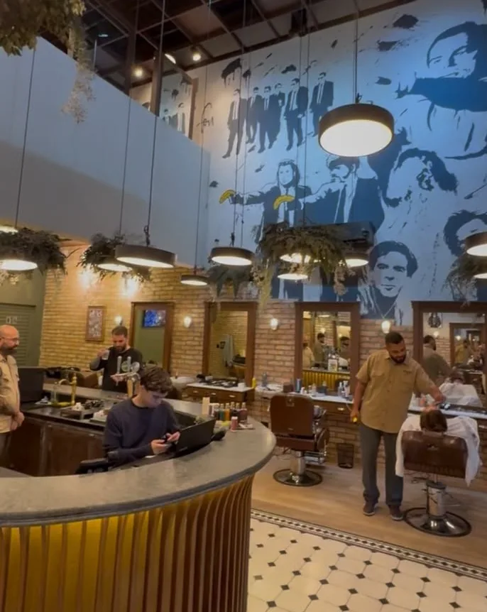 Salão da Barbearia Tarantino, com mural na parede e cadeiras de barbeiro